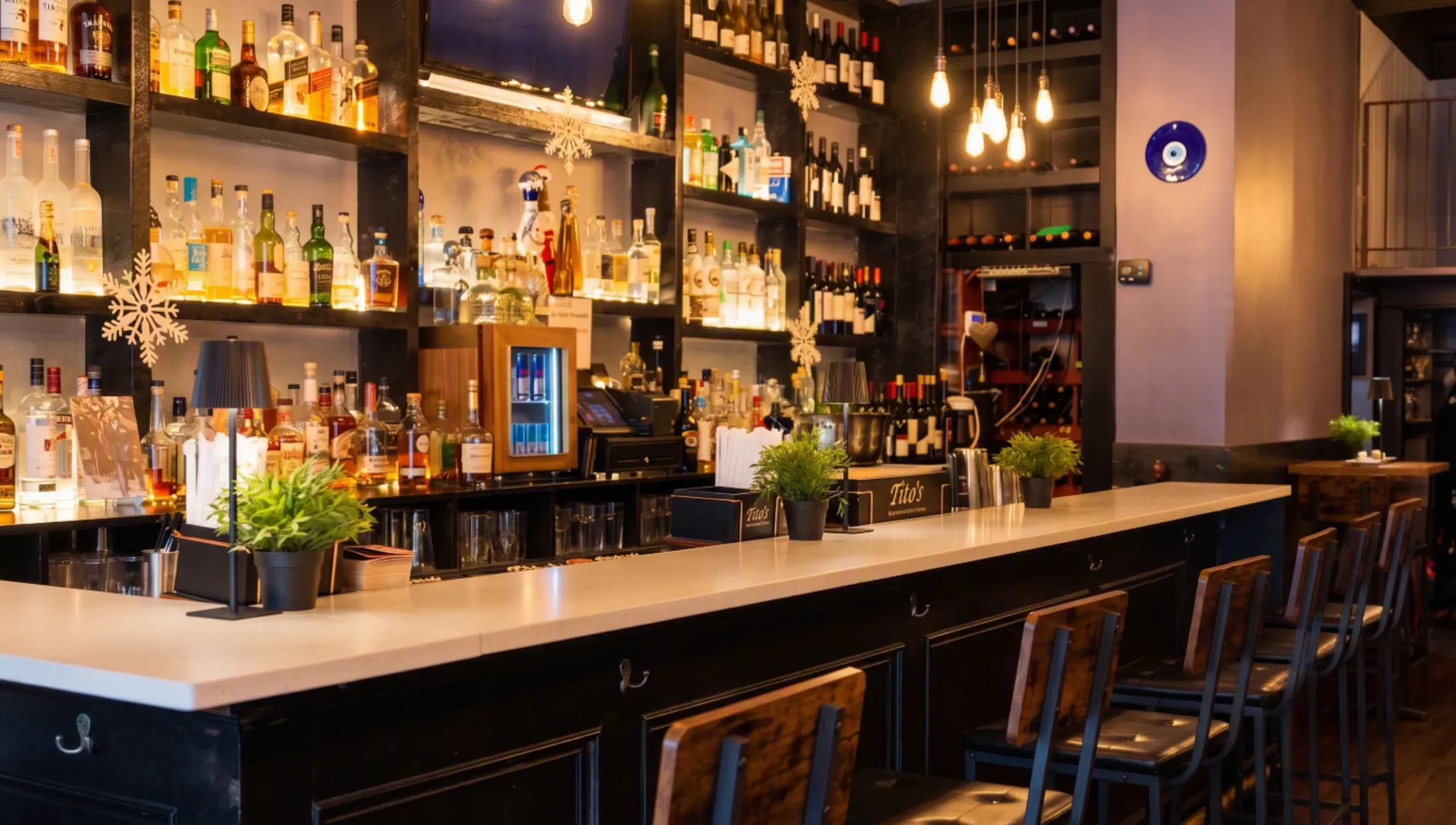 The candlelit bar at Mezè DC, shelves of spirits and wine glowing behind the counter