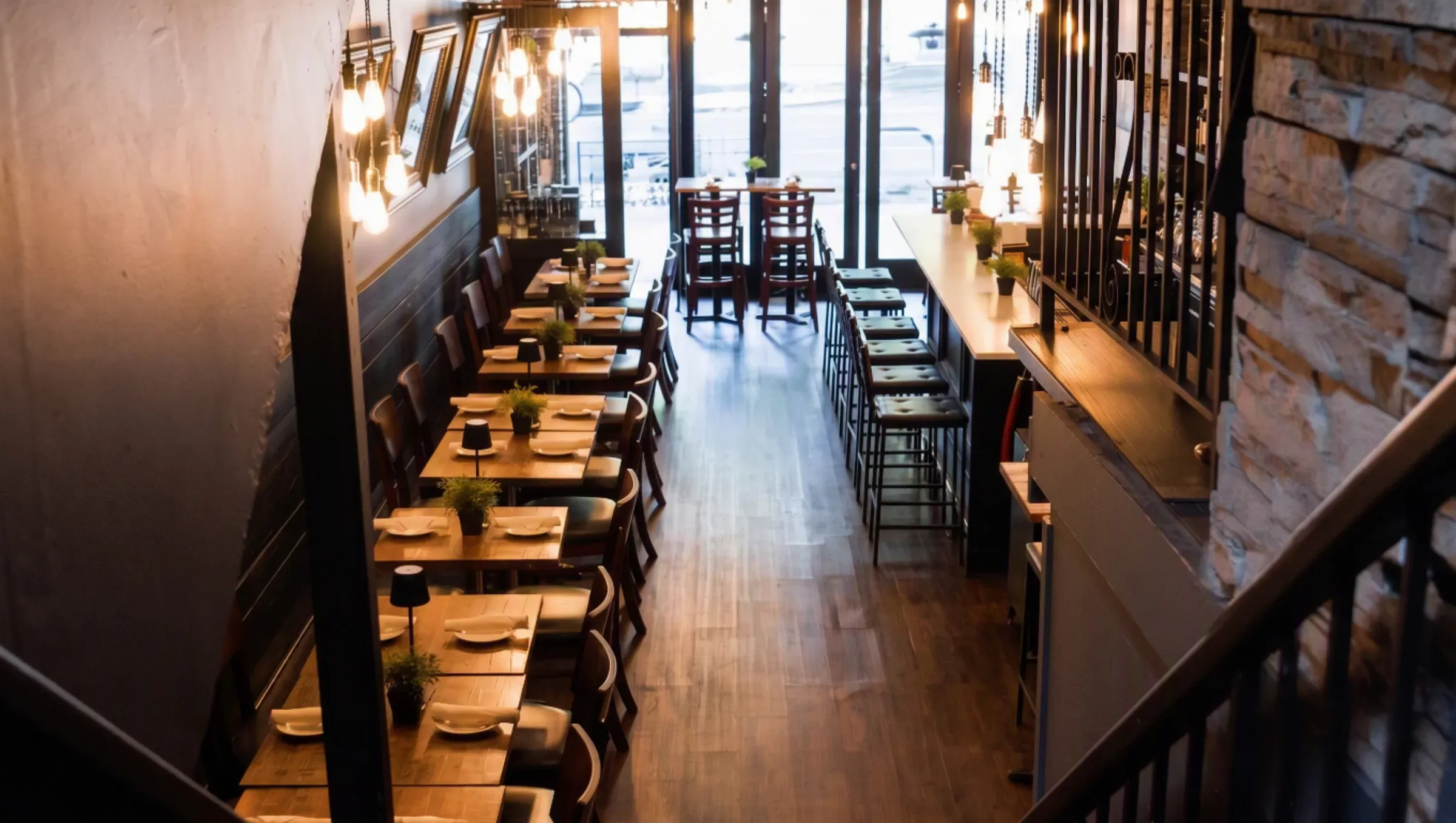 Mezè DC's dining room looking toward the 18th Street windows, stone wall and warm wood floors